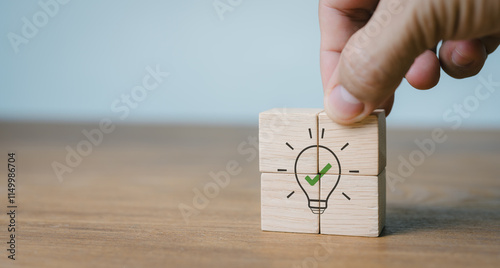 A fix. Icons of wooden cubes with lightbulb on hand are placed on grey backdrop with copy space. Business analysis, recommendations for business strategies. Concept of consultation, suggestion. photo