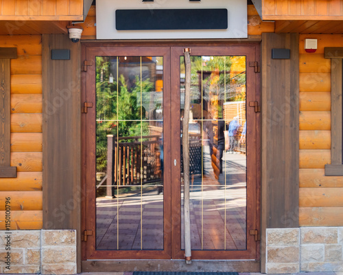 wooden door with glass inserts, opaque and reflecting the street in a restaurant or hotel building with wooden walls