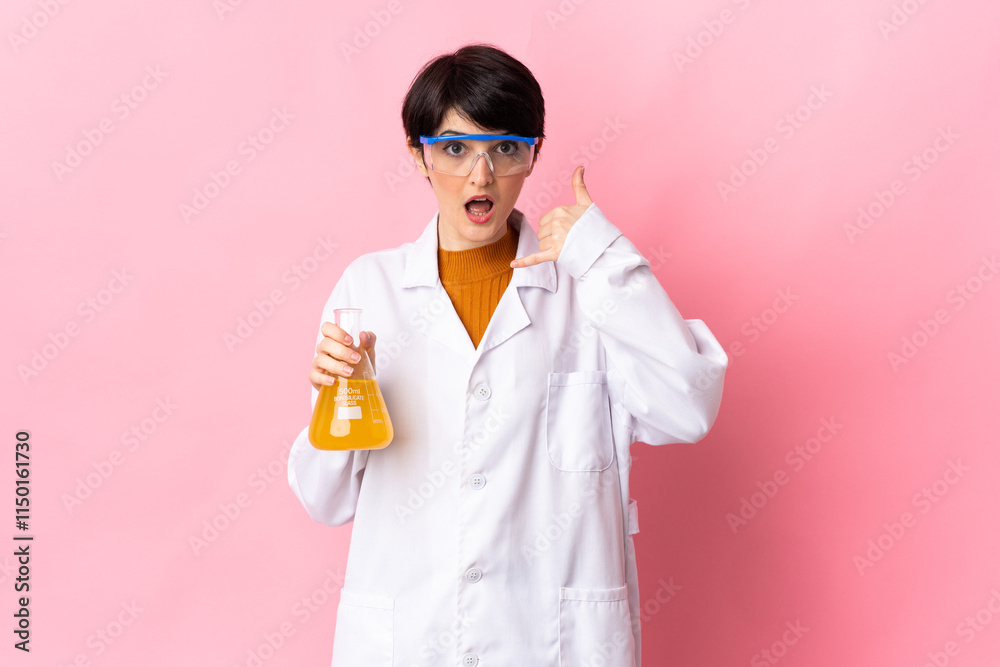 Young scientific woman isolated on pink background making phone gesture. Call me back sign Young scientific woman isolated on pink background making phone gesture. Call me back sign
