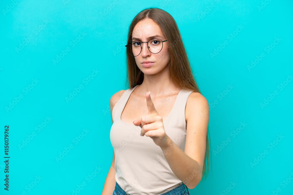 Young caucasian woman isolated on blue background frustrated and pointing to the front Young caucasian woman isolated on blue background frustrated and pointing to the front