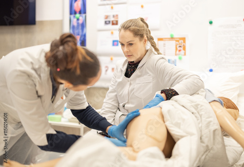 Tableau sur toile Medical Students Practicing Examination Skills on a Training Model with Serious Focus