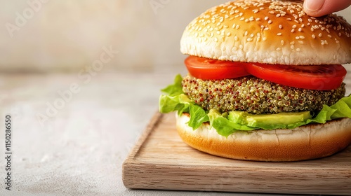 Quinoa grains inspire healthy recipes. Fresh veggie burger with lettuce and tomato on a wooden board. photo