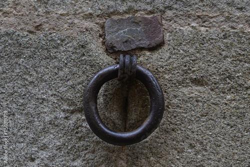 Argolla de hierro anclado en muro de piedra. photo