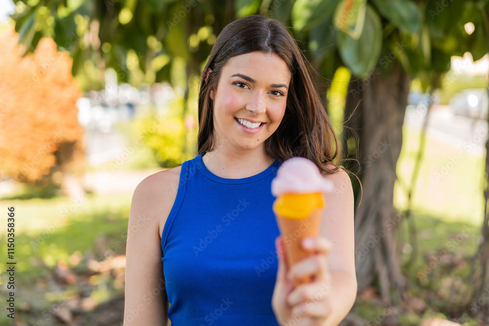 Young pretty Brazilian woman with a cornet ice cream at outdoors with happy expression Young pretty Brazilian woman with a cornet ice cream at outdoors with happy expression