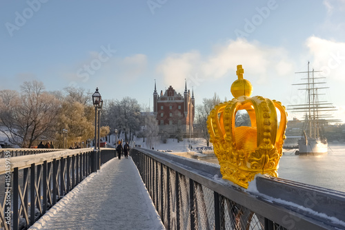 Golden crown ornament on skeppsbron bridge to skeppsholmen island bridge in central Stockholm, Sweden in winter with snow on the ground on a sunny day photo