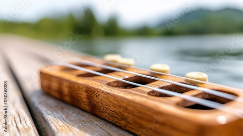 A ukulele sitting on top of a wooden table next to a lake