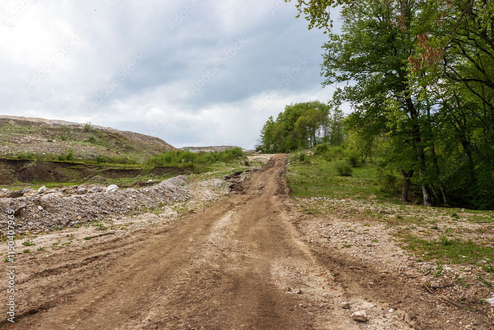 a dirt road leading to the development of a stone quarry in autumn, a quarry for the extraction of building materials a dirt road leading to the development of a stone quarry in autumn, a quarry for the extraction of building materials