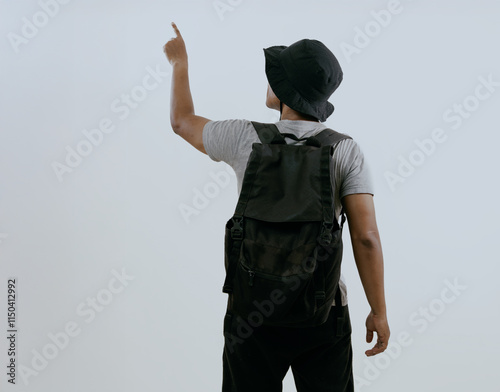 Back view of asian traveler tourist man in backpack pointing index finger to the right side isolated on white background. Concept of passenger travel on weekends and holidays. photo