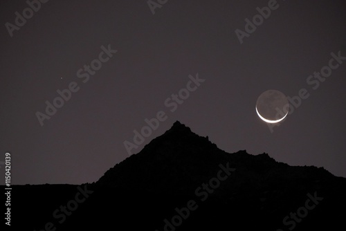 Amazing new moon seen over peak in mountains. Lobuche, Himalayas, Nepal. Everest Base Camp. photo