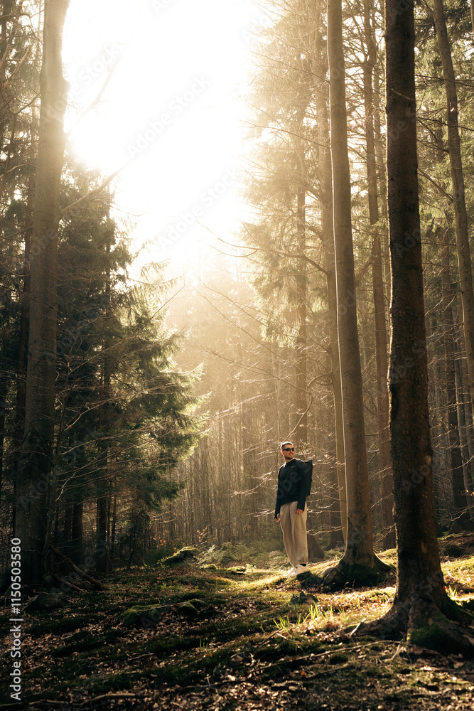 Φωτογραφία A man in a forest with sunlight shining through the trees