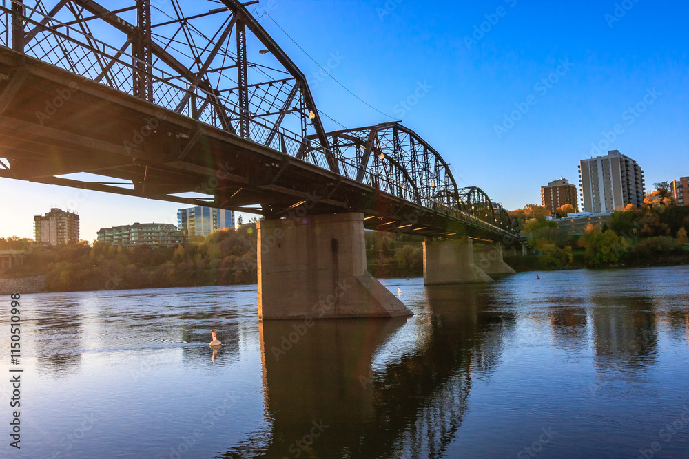 Naklejka premium A bridge spans a river with a city in the background