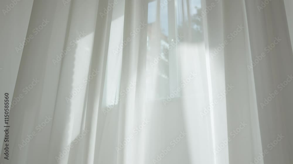 Transparent blurred white silk soft fabrics floating with sunlight shining through, shadows reflected on the textile surface, close up.