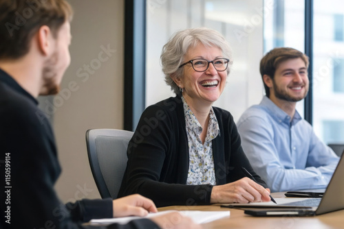 Obraz na płótnie Business professionals engaged in lively, positive conversation during meeting. Mature HR manager hold job interview with applicant, smile, lead talk gathered at conference desk. Briefing, negotiation w salonie