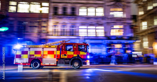 fast red firetruck on emergency call in London city center. lights on and firefighters inside. motion effect. panning effect. fire brigade UK