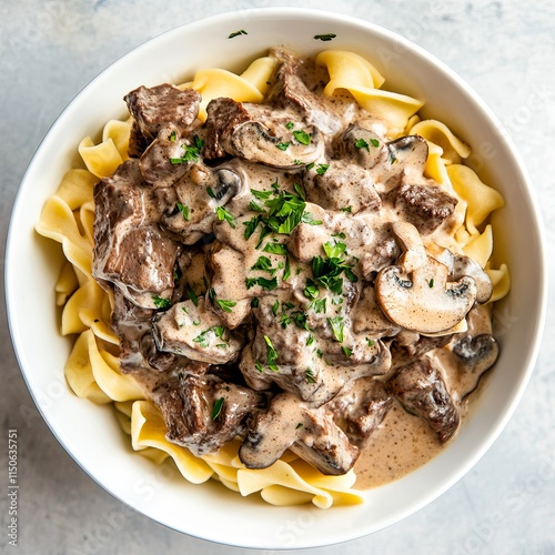 A hearty bowl of beef stroganoff with tender beef strips, mushrooms, and a creamy sauce photo