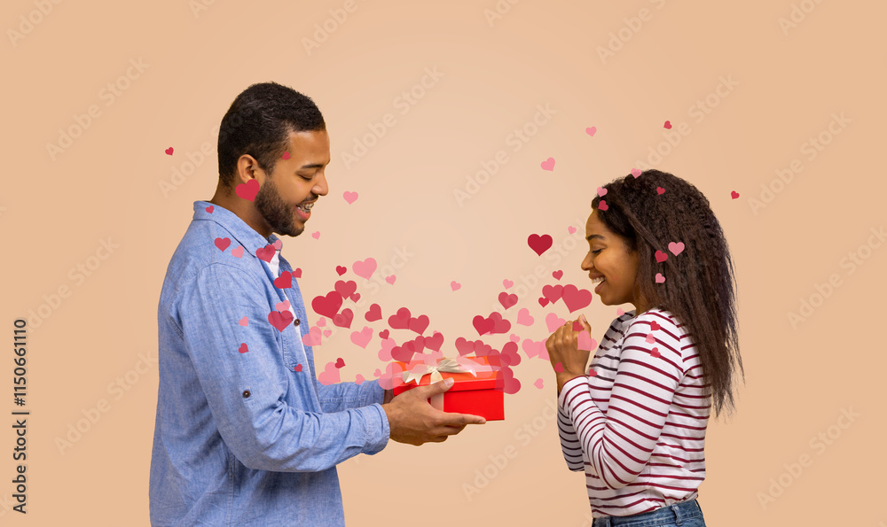 A black couple shares a special moment as the man presents a red gift box to his partner. Love is in the air, symbolized by floating hearts, perfect for any celebration of affection. A black couple shares a special moment as the man presents a red gift box to his partner. Love is in the air, symbolized by floating hearts, perfect for any celebration of affection.
