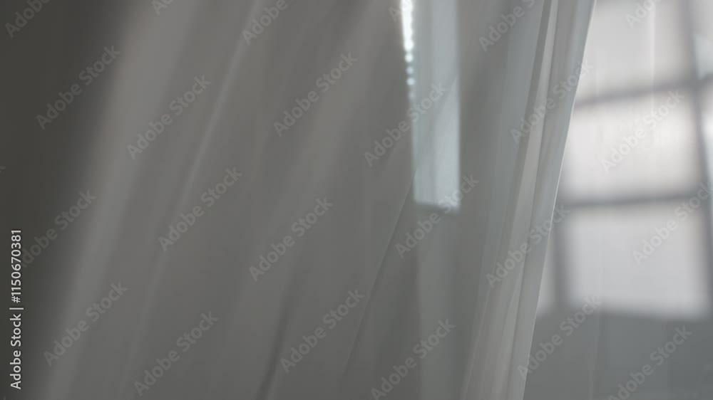 Transparent white silk soft fabrics floating with light shining through, shadows and shades reflected on the textile, close view.