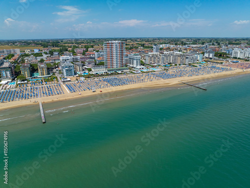 Fototapeta Naklejka Na Ścianę i Meble -  Italy, Jesolo near Bibione. Lido di Jesolo, or Jesolo Lido, is the beach area of the city of Jesolo in the province of Venice, Aerial View with sandy beach and with an endless parasols