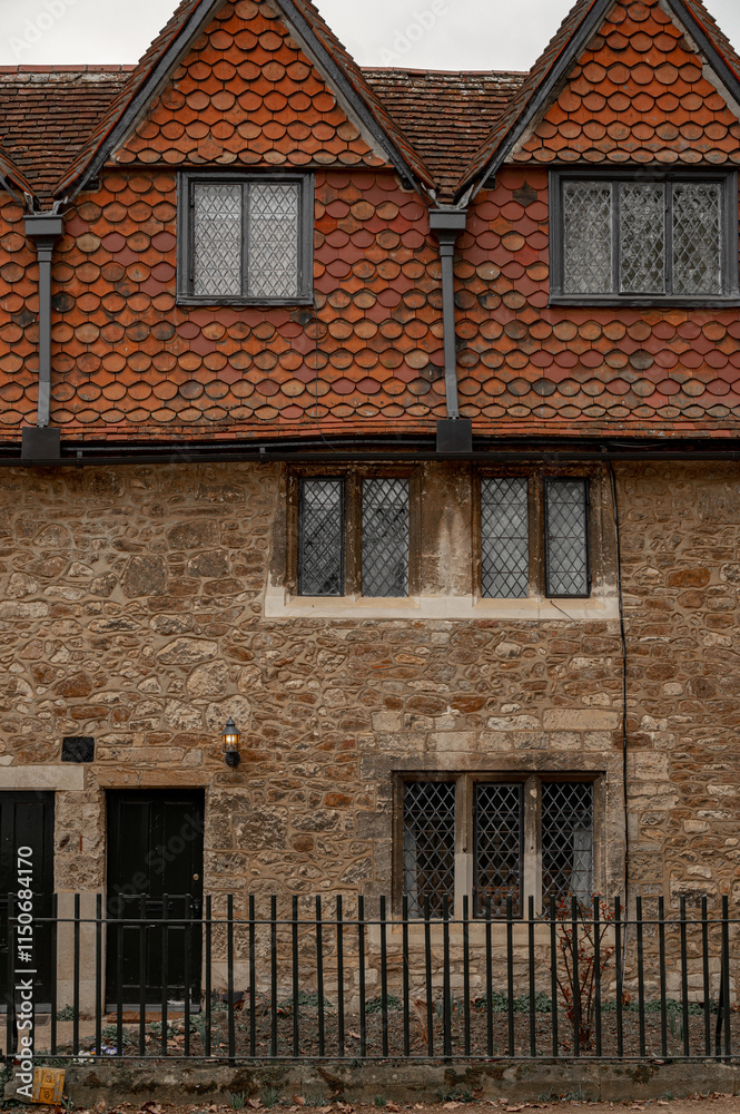 Naklejka premium Facade of a British building in Oxford with climbing plant without leaves