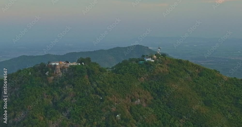 Aerial view of amazing temple on Khao Wong Phra Chan Mountain in Lopburi Province. There are about 3,790 ladder steps from the temple to the top of the mountain. surrounded by lush green hills Aerial view of amazing temple on Khao Wong Phra Chan Mountain in Lopburi Province. There are about 3,790 ladder steps from the temple to the top of the mountain. surrounded by lush green hills