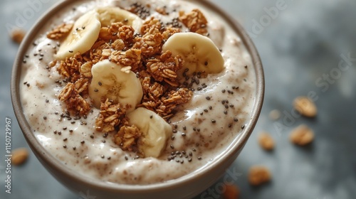 Healthy breakfast bowl with yogurt, granola, and banana slices served in a co...