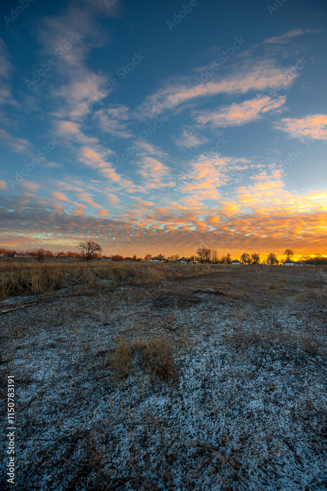 Snowy and frosty field with road,sunrise in the sky.Beautiful clouds in the sky.Nature at the winter time.Winter morning, sunlights over the road , beautiful nature landscape Snowy and frosty field with road,sunrise in the sky.Beautiful clouds in the sky.Nature at the winter time.Winter morning, sunlights over the road , beautiful nature landscape