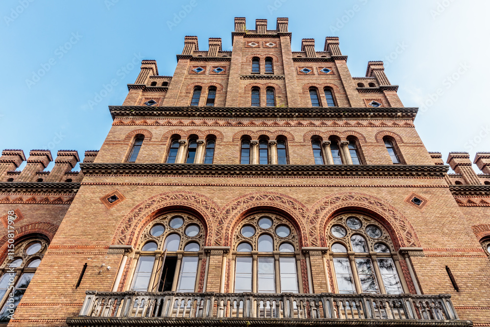 Fototapeta premium A large brick building with arched windows and a balcony