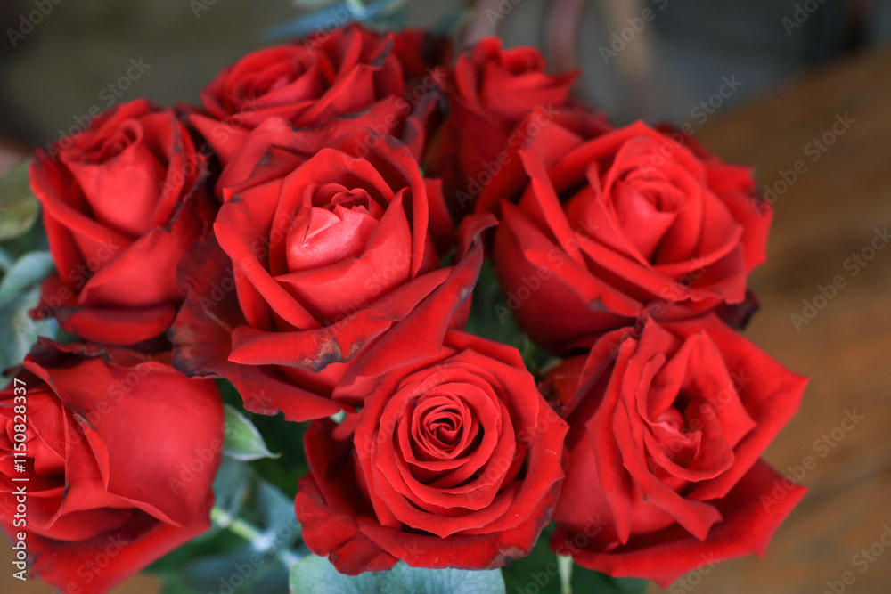 Red rose in vase on wooden table. Flowers blooming for the holiday. Home decoration. Luxury bouquet. Red rose in vase on wooden table. Flowers blooming for the holiday. Home decoration. Luxury bouquet.