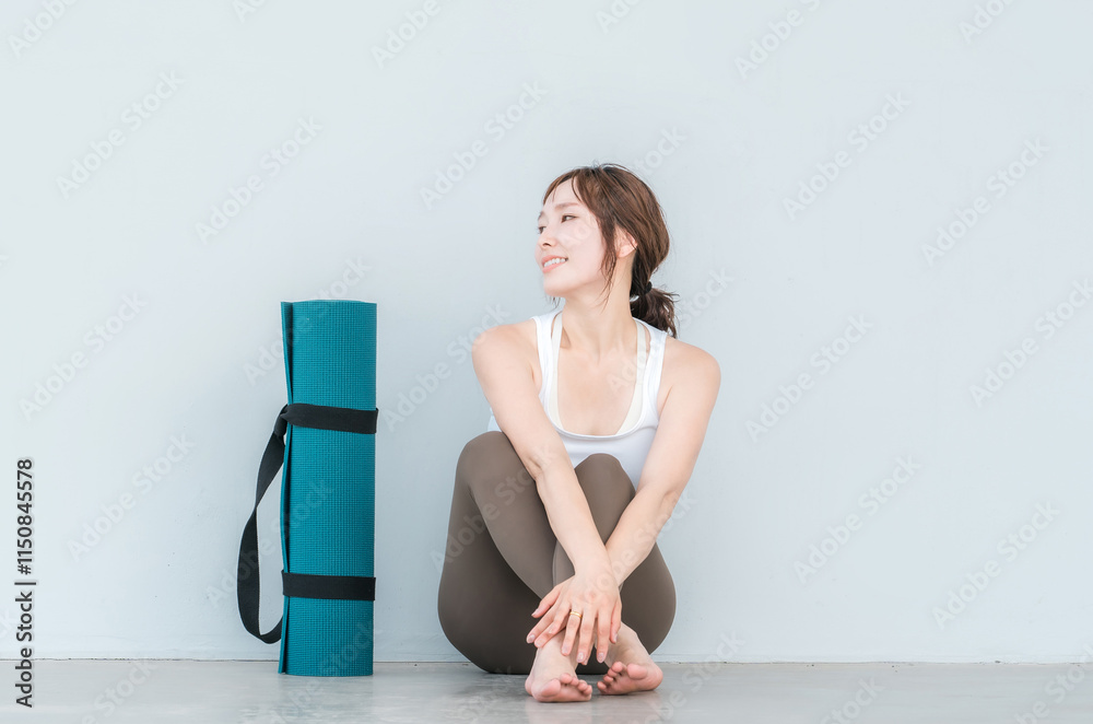 Fototapeta premium ヨガウェア・スポーツウェアを着た女性とヨガマット 