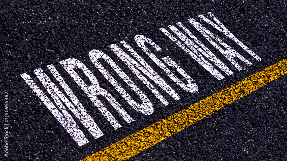 Obraz premium Wrong way, wrong way text written and yellow line on asphalt road ground.