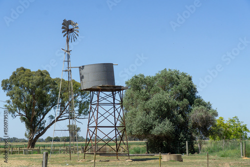 Elevated Galvanised Metal Tank elevated on a stand for storage of Freshwater with a windmill used to pump water to the tank