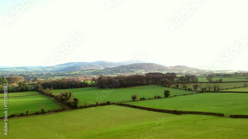 Forwards travelling aerial shot of the green fields and mountains of Slieve Gullion, an Irish summit located in County Armagh, Northern Ireland. Filmed in 4K, 50fps and in Rec709 color. photo