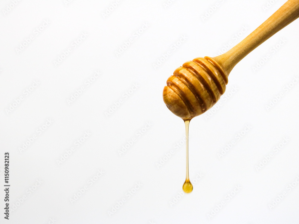 Natural honey dripping from dipper on white background Natural honey dripping from dipper on white background