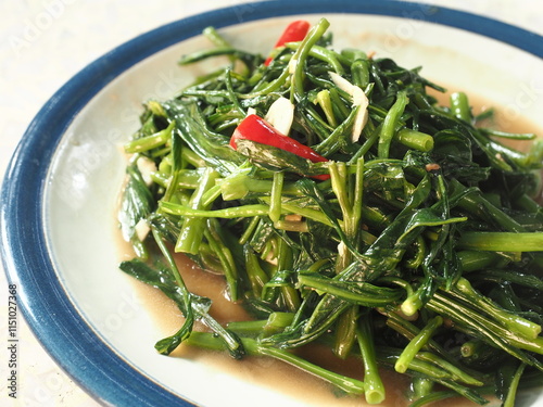 stir fried water spinach or morning glory leaves with soy sauce, garlic and red chili peppers photo