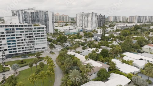Fort Lauderdale Florida drone over luxury homes with pools and palm trees approaching high-rise buildings photo