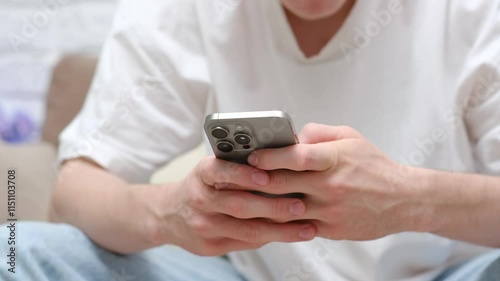 A young man is holding smartphone and looking at screen. 