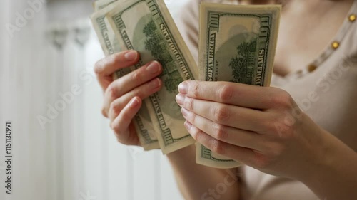Woman counts dollars with concern about the rising costs of heating her home. Financial stress arises from high energy bills and the impact of inflation on household budgets