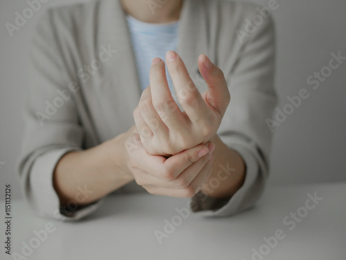 Young Asian woman feels numbness and severe pain in her wrist Caused by sitting and working for a long time Health care and office syndrome concept