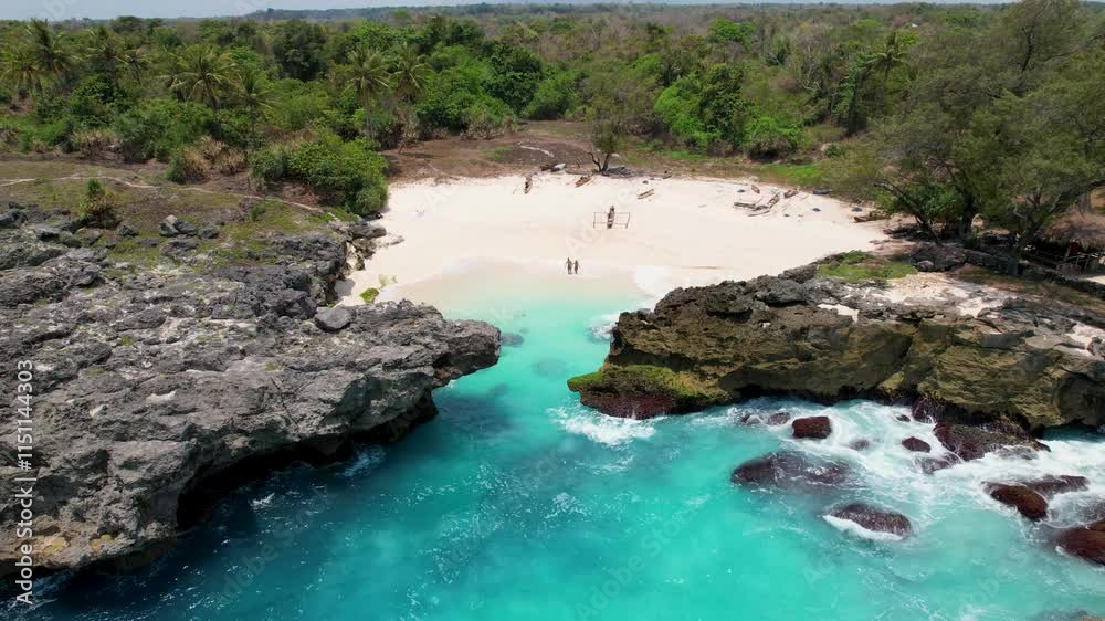 4k Drone Video of a couple standing on the white sand beach walking towards the blue ocean surrounded by cliffs and lush green landscapes on Sumba Island Indonesia 4k Drone Video of a couple standing on the white sand beach walking towards the blue ocean surrounded by cliffs and lush green landscapes on Sumba Island Indonesia
