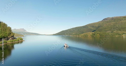 Gratangen or Rivtták, fishing boat navigating in fjord, summer season, Troms, Norway. Aerial forward, copy space photo