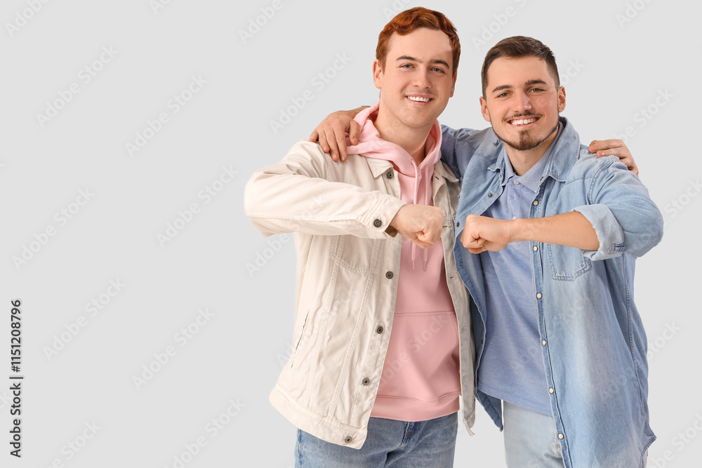 Male friends bumping fists on white background Male friends bumping fists on white background