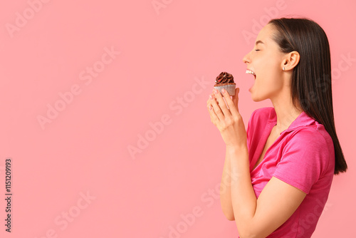 Fotografie Young woman with sweet cupcake on pink background