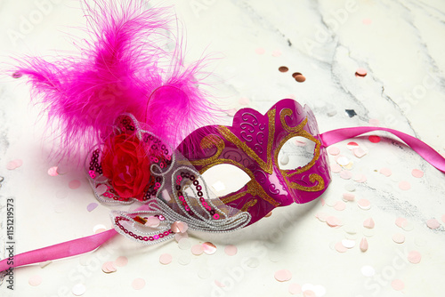 Beautiful pink carnival mask with confetti on white background photo