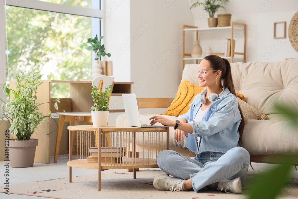 Young woman using laptop on coffee table at home Young woman using laptop on coffee table at home