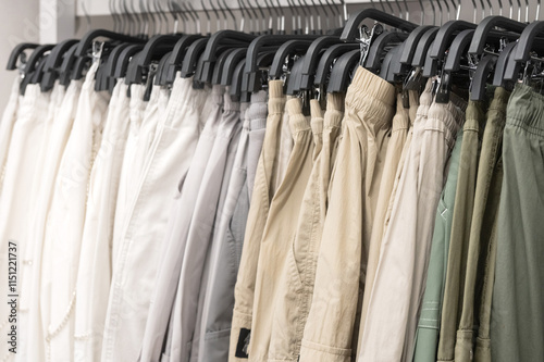 Wallpaper Mural Neutral-toned pants hanging on racks in a clothing store. Retail display photography for fashion Torontodigital.ca