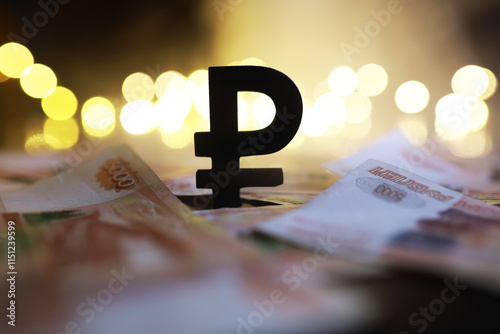 Russian Ruble Symbol with Banknotes and Bokeh Lights in the Background photo