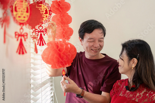 Elderly couple celebrates chinese new year with lantern decorating at home joyful atmosphere cultural tradition photo