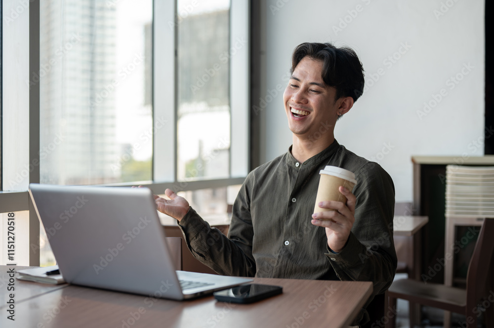 A cheerful businessman working remotely from a coffee shop, having an online meeting with his team. A cheerful businessman working remotely from a coffee shop, having an online meeting with his team.