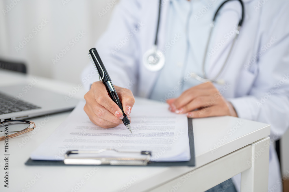 A close-up of a doctor working at her desk in the office, reading and checking the medical paper. A close-up of a doctor working at her desk in the office, reading and checking the medical paper.