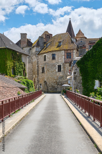 View at the medieval village of Carennac in Lot Occitanie Southern France from the bridge under a blue sky with clouds in summer. Image withe copy space